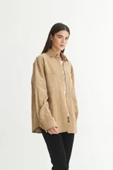 Sobrecamisa color beige de pana con cuello solapa clásico, bolsillos cuadrados en el pecho, botones personalizados y calce holgado.