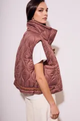 Chaleco acolchado color marrón con cierre frontal y bolsillos laterales.