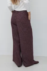 Pantalón de corte ancho y tiro alto, confeccionado en tejido con textura tipo espiga en color azul. Presenta pinzas en la cintura y costuras reforzadas.