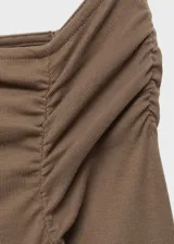 Vestido largo de diseño asimétrico y entallado, con escote off-shoulder y manga larga. Presenta detalles fruncidos en uno de los hombros y abertura en la parte posterior.