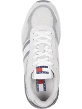 Zapatillas Tommy Jeans blancas y grises con detalles en rojo y azul. Presentan el logo de Tommy Jeans en el lateral y suela dentada. Confeccionadas con poliéster reciclado.