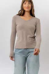 Remera de manga larga color beige, con escote redondo levemente abierto y calce regular. Confeccionada en tejido suave, liviano y con leve elasticidad.