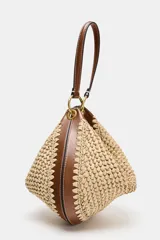 Bolso saca de formato multiposición con cuerpo de efecto trenzado y detalles en combinación de materiales. Cuenta con asa combinada con anillas metálicas, bolsillo interior con cremallera y cierre mediante cremallera metálica.
