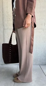 Pantalón de tejido de punto acanalado en color beige, con corte recto y holgado. Presenta cintura elástica con cordón ajustable y terminaciones simples.