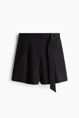 Short de tiro alto con diseño sastrero, confeccionado en tejido de punto pesado. Presenta pinzas frontales, elástico oculto en la parte posterior y un cinturón integrado con anillas metálicas en D en el lateral.