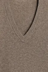 Jersey de punto liso confeccionado en mezcla de cashmere y lana, con cuello en pico y manga larga de diseño holgado.