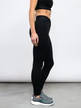 Calza deportiva Umbro modelo Legging Bink para mujer, de color negro, con cintura alta cruzada y elástica con la marca estampada.