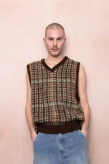 Chaleco de punto con patrón de cuadros en tonos marrón, beige, verde y celeste, con cuello en V y ribete marrón.