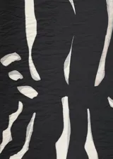 Vestido corto con estampado animal print de cebra en blanco y negro, de corte recto, escote cuadrado, tirantes finos y sin mangas.