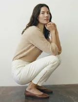 Pantalón tipo jegging de denim color blanco roto, tiro alto, corte recto al tobillo con cierre funcional en el ruedo. Diseño pull-on sin cierre ni botón frontal, con bolsillos funcionales traseros y simulados delanteros.