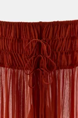 Pantalón semitransparente de pernera ancha, tiro medio y cintura elástica ajustable con lazadas, confeccionado en 100% viscosa.