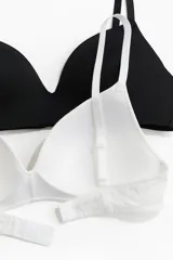 Pack de dos soutiens de microfibra, uno negro y uno blanco, con copas acolchadas, breteles ajustables y cierre de corchetes en la espalda. Diseño sin aros.