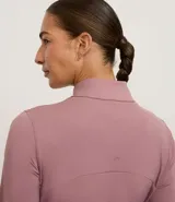 Campera deportiva de ajuste entallado con cierre frontal completo, cuello alto y mangas largas. Presenta recortes anatómicos que siguen la silueta y bolsillos laterales invisibles. Confeccionada en tejido técnico de alta elasticidad.