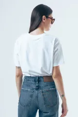 Camiseta básica de manga corta, cuello redondo y corte recto, confeccionada en algodón de color blanco.