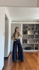 Pantalón de jean en tono azul oscuro con corte wide leg, tiro alto y bolsillos frontales tipo parche. Presenta costuras a contratono y un diseño de pierna ancha.