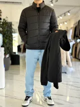 Campera 2 en 1 impermeable de color negro, con diseño con capucha y cierre frontal completo.