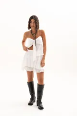 Pollera corta de encaje blanco con diseño de volados escalonados y cintura elástica.