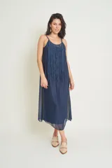 Vestido midi azul de seda natural con breteles finos y escote redondo. Presenta detalle de flecos largos en el frente.