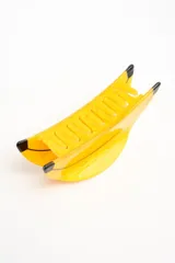 Broche para el pelo en forma de banana, color amarillo con detalles en negro, fabricado en acetato.
