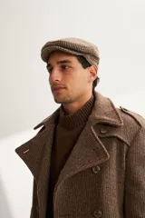 Boina con visera de lana fina uruguaya natural, sin teñir, con diseño de tejido texturizado en tonos beige y marrón.