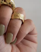 Anillo plateado con textura irregular y diseño rústico.