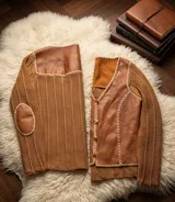 Saco artesanal de tejido de punto con frente y coderas de cuero, espalda de lana y detalles de bordado artesanal en los bordes y costuras. Cuenta con cierre frontal de botones.