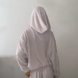 Hoodie de punto color beige, de diseño holgado con mangas largas y cordones ajustables en el cuello.