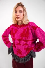 Sweater de lana merino tejido a mano con diseño geométrico y figuras de llamas, de cuello redondo y corte holgado, con flecos grises en el ruedo.
