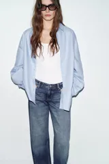 Jeans de tiro bajo con diseño de cinco bolsillos, corte recto y cierre frontal con cremallera y botón.