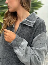 Vestido largo de punto en color verde oliva, con diseño de paneles en dos tonos de verde, mangas largas con textura perforada y tajos laterales en el ruedo.