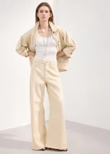 Jeans de corte wide leg en color beige, con tiro medio-alto, bolsillos clásicos y cierre frontal con botón y cremallera.