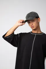 Remera de corte oversize color malva, confeccionada en algodón pesado, con costuras externas visibles en color blanco que recorren el centro, el cuello y los bordes de las mangas.