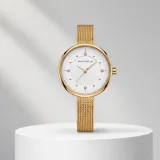 Reloj analógico Mini Focus con caja redonda de metal dorado y malla de acero tipo milanesa. Esfera blanca minimalista con indicadores de hora en puntos dorados y movimiento de cuarzo japonés.