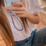 Llavero para celular con cuentas facetadas de color azul y cuentas plateadas.