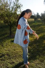 Cárdigan celeste pálido de lana merino con bordados florales color ladrillo hechos a mano.