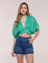 Short de denim blanco tiro alto, estilo pull-on con cintura elástica ancha, bolsillos delanteros y traseros, y dobladillo en las piernas.