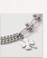 Pulsera de plata con diseño de cadena múltiple y dije colgante en forma de trébol de cuatro hojas.