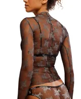 Top de manga larga confeccionado en malla transparente con diseño bicolor y bordado floral. Presenta cuello tipo mock, detalle de orificios para los pulgares y ruedo con vuelo, de silueta relajada y sin forro.
