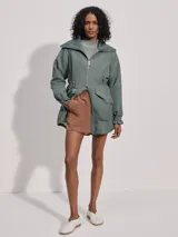 Campera larga color verde con cuello acanalado, cierre de doble sentido, bolsillos de parche grandes, cintura interior ajustable y puños con borde con volados.