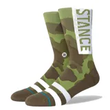 Medias Stance con diseño de camuflado militar en tonos verdes y marrones, caña media con franja blanca vertical y el nombre de la marca en contraste. Cuentan con bandas blancas horizontales en el empeine y puntera reforzada.