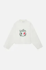 Buzo de corte boxy color crudo, con cuello redondo y mangas largas de hombros caídos. Presenta un estampado frontal con el logo de la marca, un escudo con los colores de la bandera italiana y detalles de laureles.