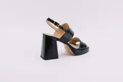 Sandalias de plataforma color crema, con tiras anchas de charol y hebilla ajustable en el tobillo.