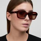 Lentes de sol con montura cuadrada de diseño retro inspirado en los años 70, en color marrón translúcido con cristales polarizados en tono marrón.