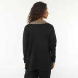 Chaqueta larga de punto fino color negro, con cuello en V y cierre frontal abotonado.