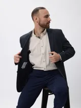 Blazer de tweed color azul marino con coderas en contraste, cierre frontal de botones y bolsillos laterales. Presenta un diseño clásico de corte regular.