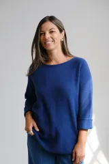 Sweater de tejido de punto color azul, con escote a la base y mangas largas con puños doblados.