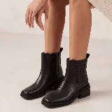 Bota tipo chelsea de cuero vacuno color suela, con diseño de punta cuadrada y elástico lateral. Cuenta con taco de madera y suela de plataforma baja.