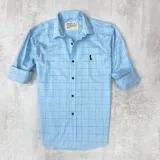 Camisa celeste a cuadros finos con cuello clásico, manga larga con puños abotonados y cierre frontal con botones.
