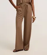 Pantalón celeste de corte recto, confeccionado en tejido orly con elástico y lazo en la cintura.