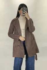 Trench de gamuza sintética color tostado, con diseño de doble botonadura, solapas clásicas y cinturón ajustable a la cintura. Cuenta con bolsillos laterales y mangas largas.